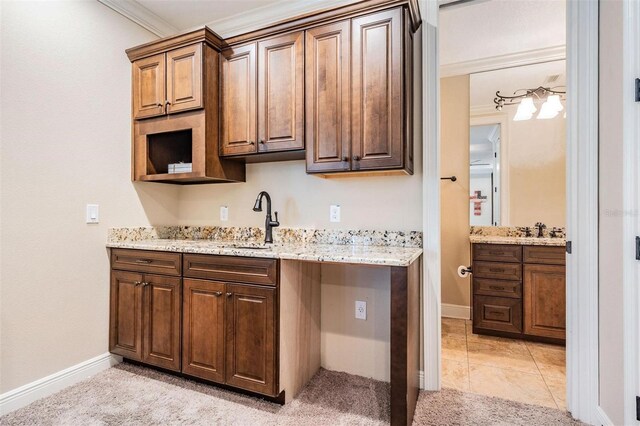 5914 Fitzgerald Rd, Odessa, FL 33556 - kitchen with a sink, ornamental molding, baseboards, and light stone countertops