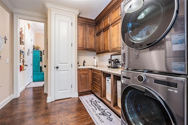 5914 Fitzgerald Rd, Odessa, FL 33556 - clothes washing area with stacked washer / drying machine, cabinet space, dark wood-type flooring, baseboards, and crown molding