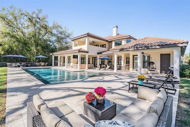 5914 Fitzgerald Rd, Odessa, FL 33556 - rear view of house with an outdoor living space, ceiling fan, a patio area, a tile roof, and a chimney