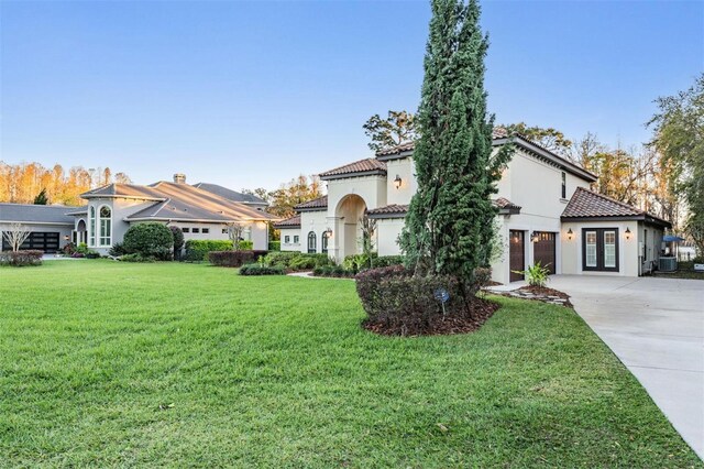 5914 Fitzgerald Rd, Odessa, FL 33556 - mediterranean / spanish-style home with concrete driveway, french doors, a tiled roof, and a front lawn