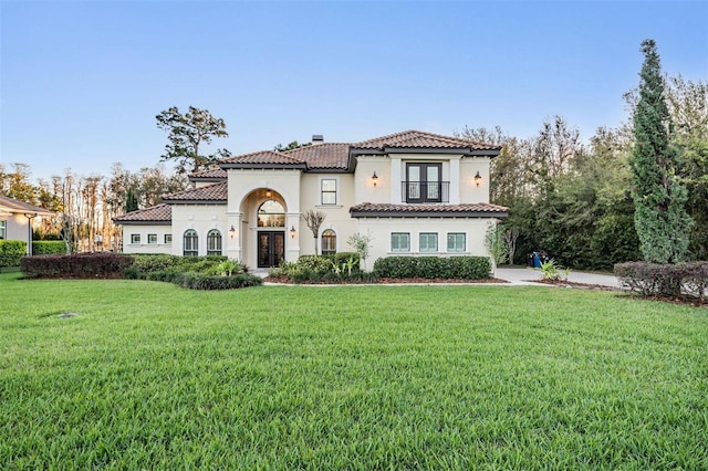 5914 Fitzgerald Rd, Odessa, FL 33556 - mediterranean / spanish-style house featuring french doors, a chimney, a front lawn, stucco siding, and a tile roof