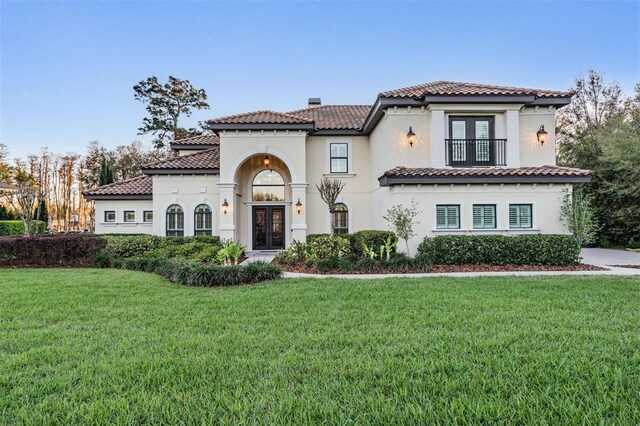 5914 Fitzgerald Rd, Odessa, FL 33556 - mediterranean / spanish-style home featuring french doors, a front lawn, stucco siding, and a chimney