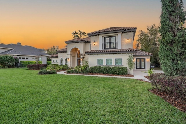 5914 Fitzgerald Rd, Odessa, FL 33556 - mediterranean / spanish home featuring french doors, a yard, a tiled roof, stucco siding, and a balcony