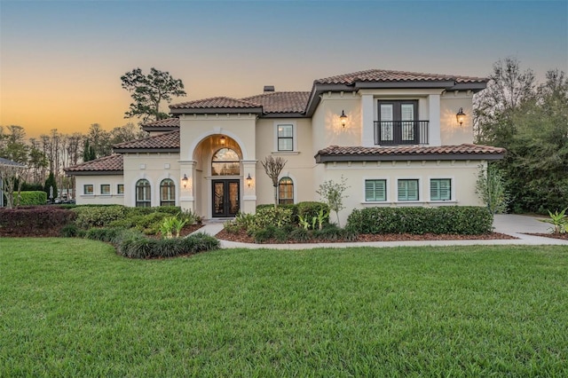 5914 Fitzgerald Rd, Odessa, FL 33556 - mediterranean / spanish-style house with french doors, a yard, a balcony, and a tiled roof