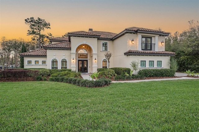 5914 Fitzgerald Rd, Odessa, FL 33556 - mediterranean / spanish-style house with french doors, a tiled roof, a yard, and a chimney