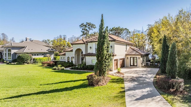 5914 Fitzgerald Rd, Odessa, FL 33556 - mediterranean / spanish house featuring a tile roof, driveway, stucco siding, a front lawn, and central AC