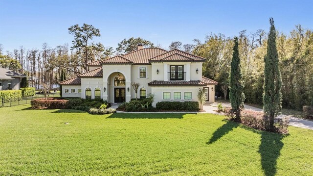 5914 Fitzgerald Rd, Odessa, FL 33556 - mediterranean / spanish-style home featuring french doors, a chimney, driveway, a tiled roof, and stucco siding