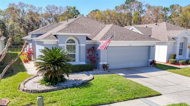 single story home featuring a garage, a shingled roof, concrete driveway, and stucco siding