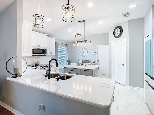 kitchen with stainless steel appliances, recessed lighting, visible vents, a sink, and a peninsula