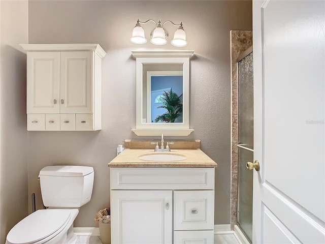 bathroom with toilet, a shower stall, and vanity