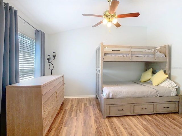 bedroom featuring lofted ceiling, ceiling fan, light wood-style flooring, and baseboards