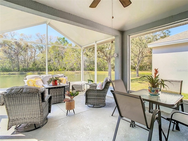 sunroom with a water view, a healthy amount of sunlight, a ceiling fan, and lofted ceiling