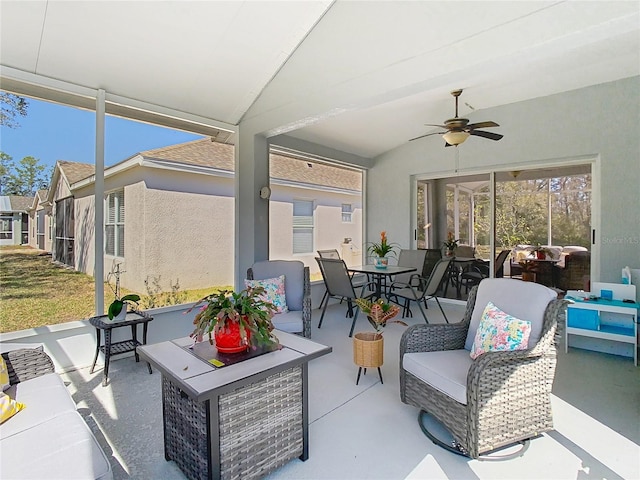 sunroom featuring a ceiling fan, a healthy amount of sunlight, and vaulted ceiling