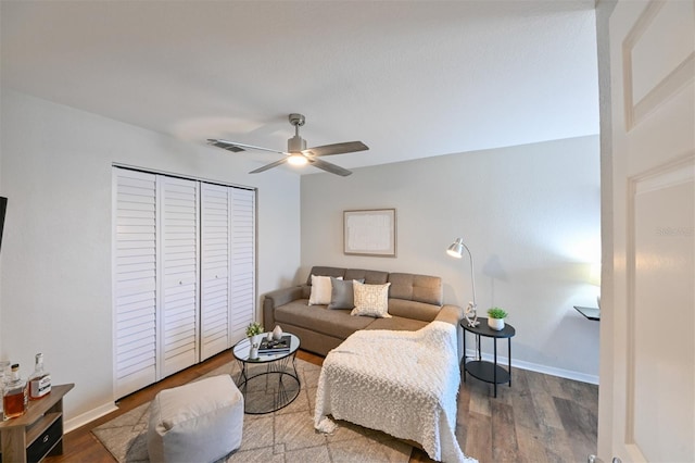 living room with wood finished floors, visible vents, baseboards, and ceiling fan