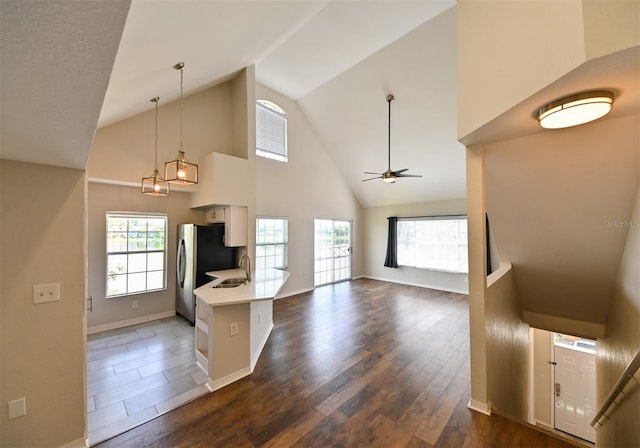 9730 Lake Chase Island Way Unit 9730, Tampa, FL 33626 - kitchen featuring a ceiling fan, light countertops, high vaulted ceiling, dark wood finished floors, and healthy amount of natural light