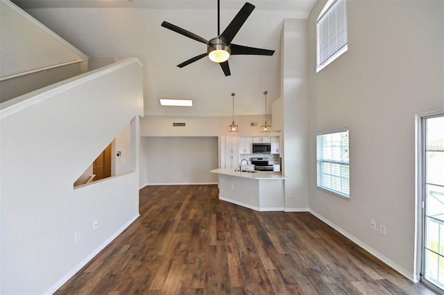 9730 Lake Chase Island Way Unit 9730, Tampa, FL 33626 - unfurnished living room with a ceiling fan, dark wood-style flooring, and a high ceiling