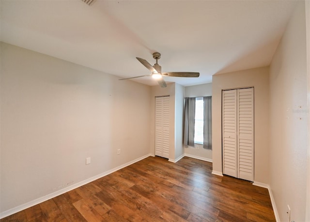 9730 Lake Chase Island Way Unit 9730, Tampa, FL 33626 - unfurnished bedroom featuring multiple closets, dark wood-style flooring, and ceiling fan