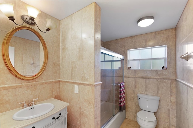 bathroom with toilet, combined bath / shower with glass door, tile walls, and a healthy amount of sunlight