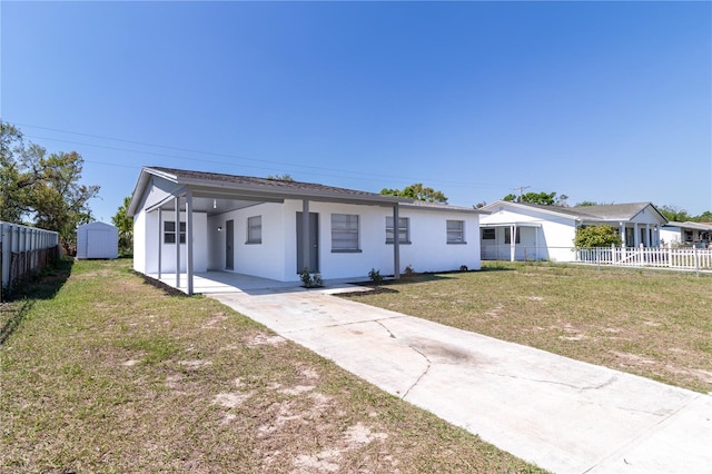 single story home featuring fence, driveway, stucco siding, a carport, and a front lawn