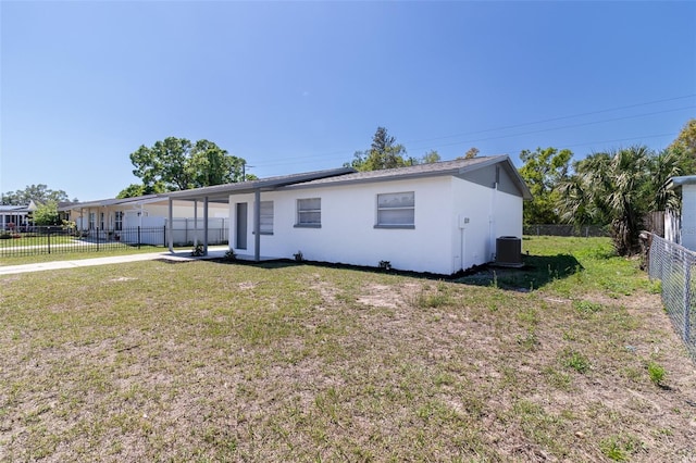 ranch-style house with central air condition unit, fence private yard, a front yard, and stucco siding