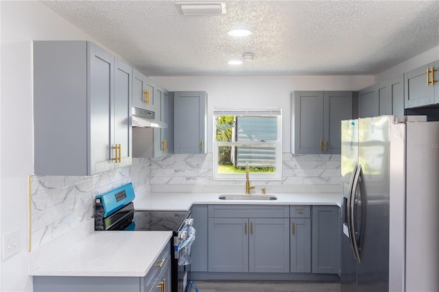 kitchen with visible vents, a sink, under cabinet range hood, tasteful backsplash, and appliances with stainless steel finishes