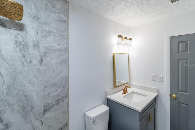 bathroom with toilet, a textured ceiling, and vanity