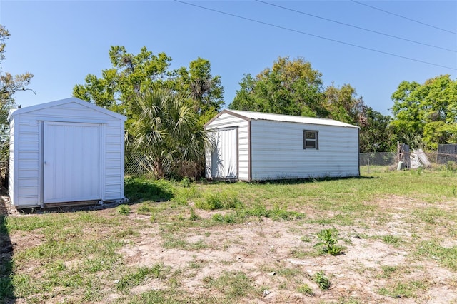 view of yard with an outbuilding, a storage unit, and fence