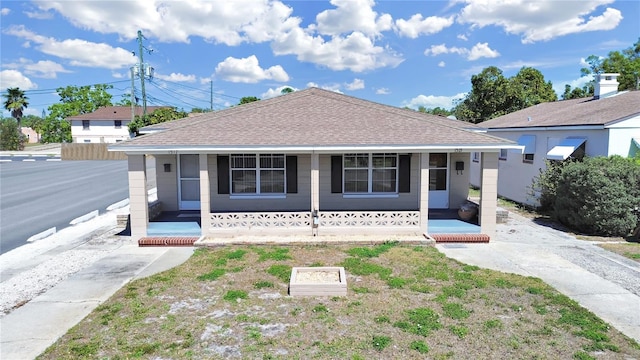 bungalow with covered porch and roof with shingles