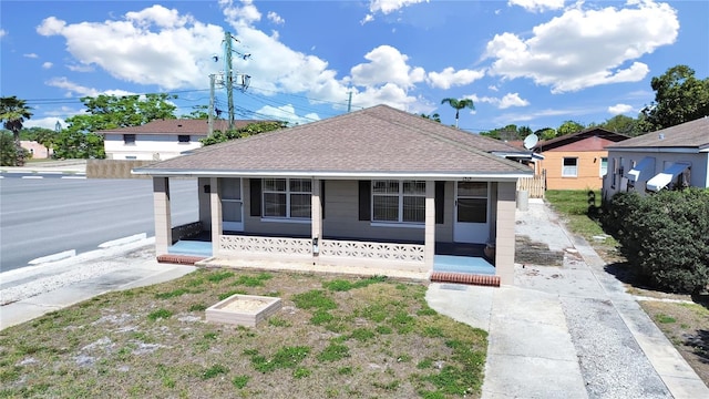 bungalow-style home with roof with shingles