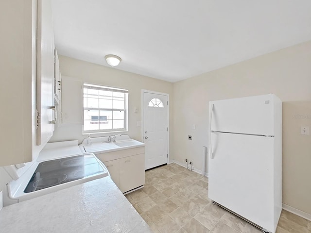 washroom featuring a sink, baseboards, and laundry area