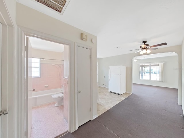 hallway with visible vents, a wealth of natural light, and carpet floors