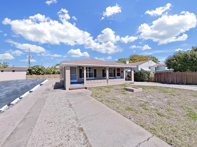 view of front facade with a porch, roof with shingles, and fence