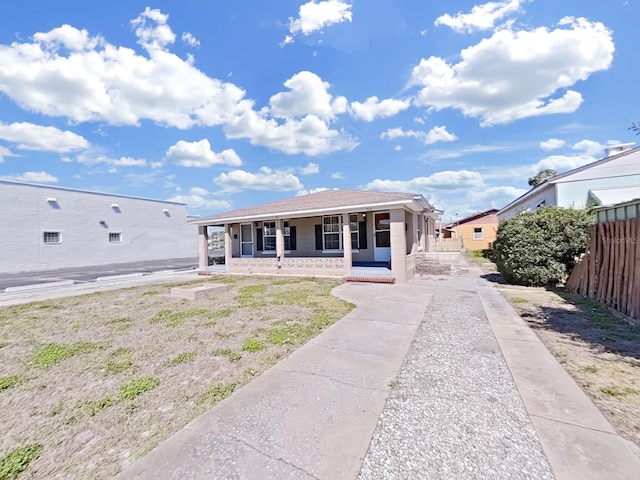 view of front of home with a porch and fence