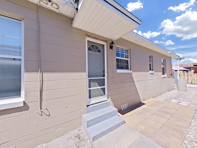 entrance to property with crawl space, a patio area, and fence