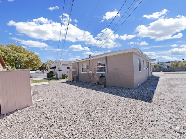 back of house featuring central air condition unit and fence