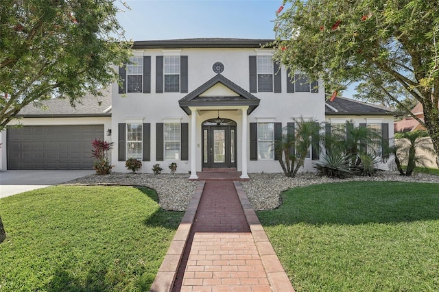 view of front of property featuring stucco siding, driveway, an attached garage, and a front yard