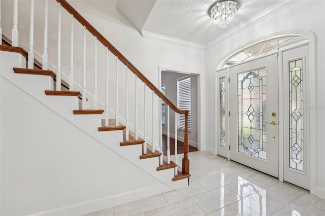 entrance foyer with a notable chandelier, a textured ceiling, crown molding, baseboards, and stairs