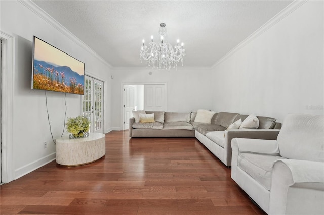 living room with a textured ceiling, crown molding, an inviting chandelier, and wood finished floors