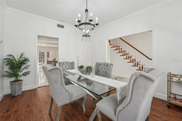 dining room featuring visible vents, baseboards, wood finished floors, and crown molding