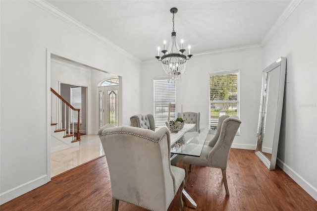 dining room with dark wood finished floors, a chandelier, baseboards, and ornamental molding