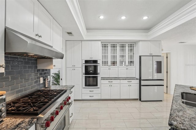 kitchen with under cabinet range hood, visible vents, stainless steel appliances, and a tray ceiling