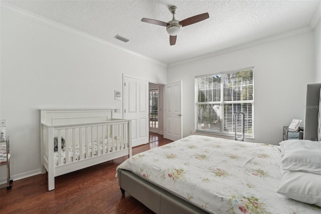 bedroom with visible vents, crown molding, a textured ceiling, a ceiling fan, and dark wood-style flooring