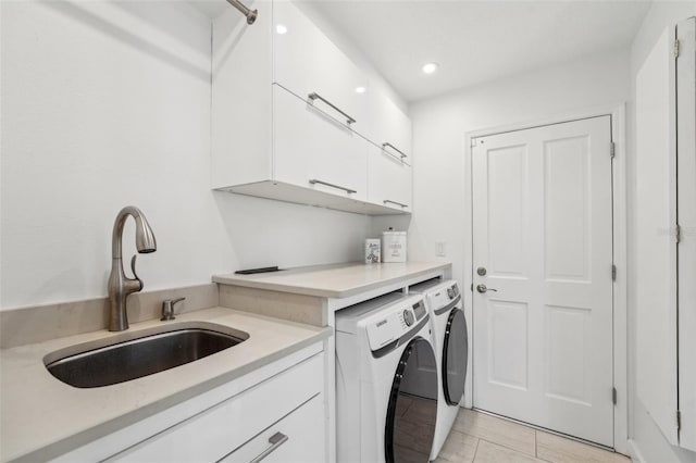 laundry room featuring recessed lighting, cabinet space, washer and dryer, and a sink