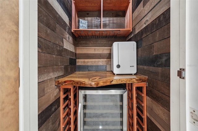 interior space featuring beverage cooler and wood walls