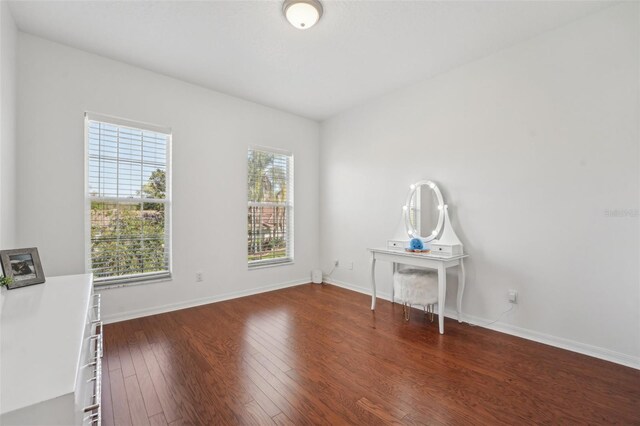 unfurnished room featuring hardwood / wood-style floors and baseboards