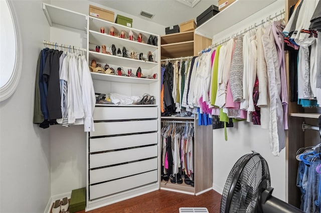 walk in closet with visible vents, attic access, and wood finished floors