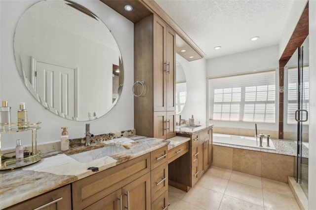 bathroom featuring two vanities, a sink, a textured ceiling, tile patterned flooring, and a bath