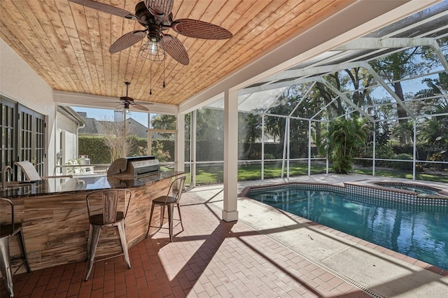 outdoor pool with outdoor wet bar, grilling area, glass enclosure, an outdoor kitchen, and a patio area