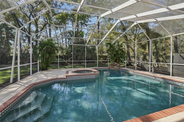 view of pool featuring glass enclosure, a pool with connected hot tub, and a patio