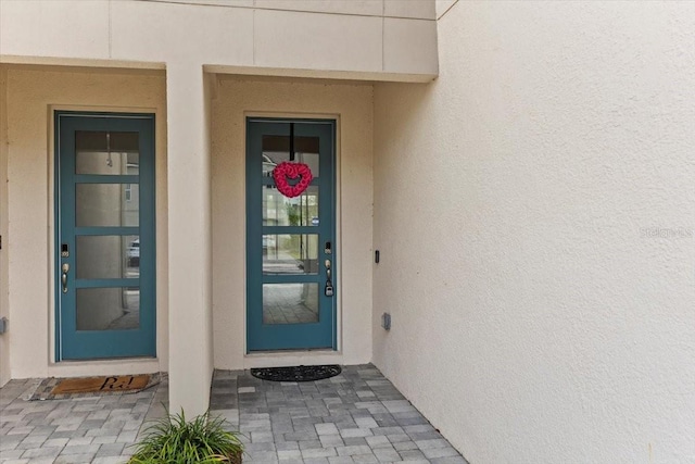 property entrance with stucco siding